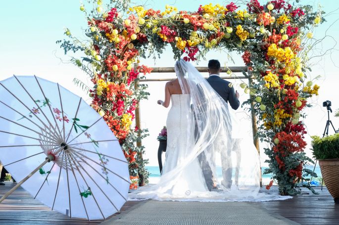 Arco de flores em tons quentes para casamento em buzios